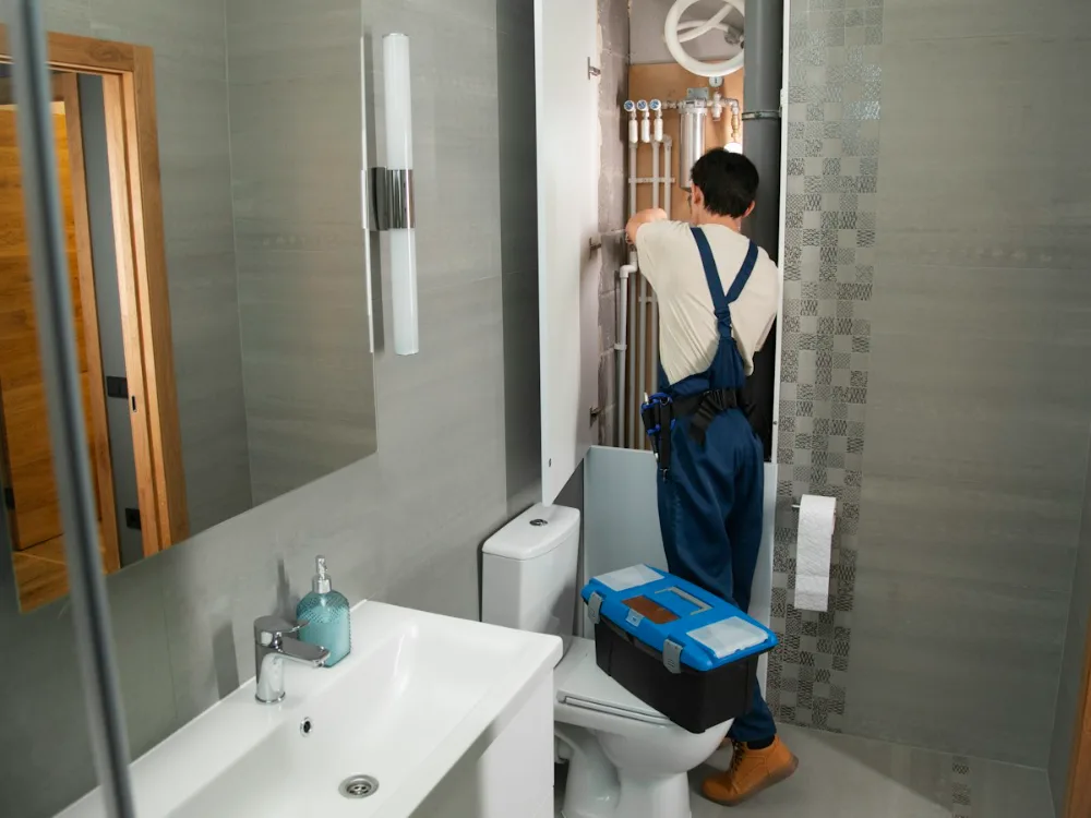 Plumber working on the supply lines in a bathroom under renovation