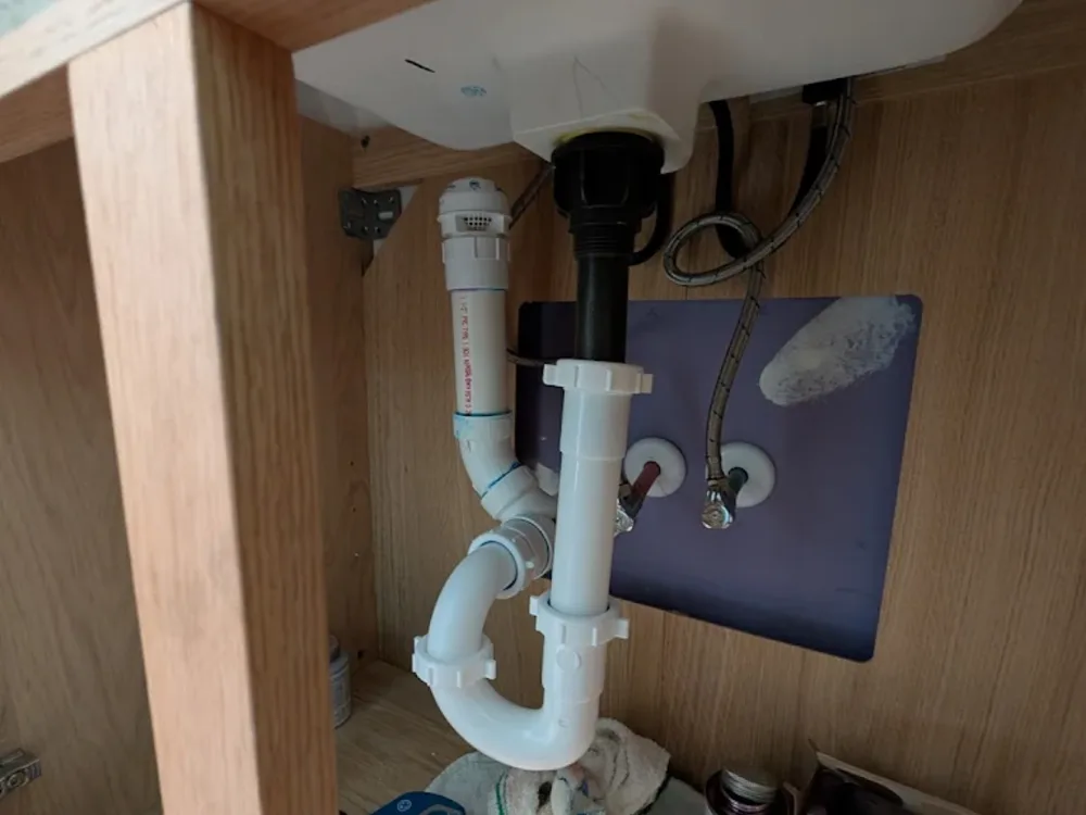 New trap and supply lines fitted under a bathroom basin