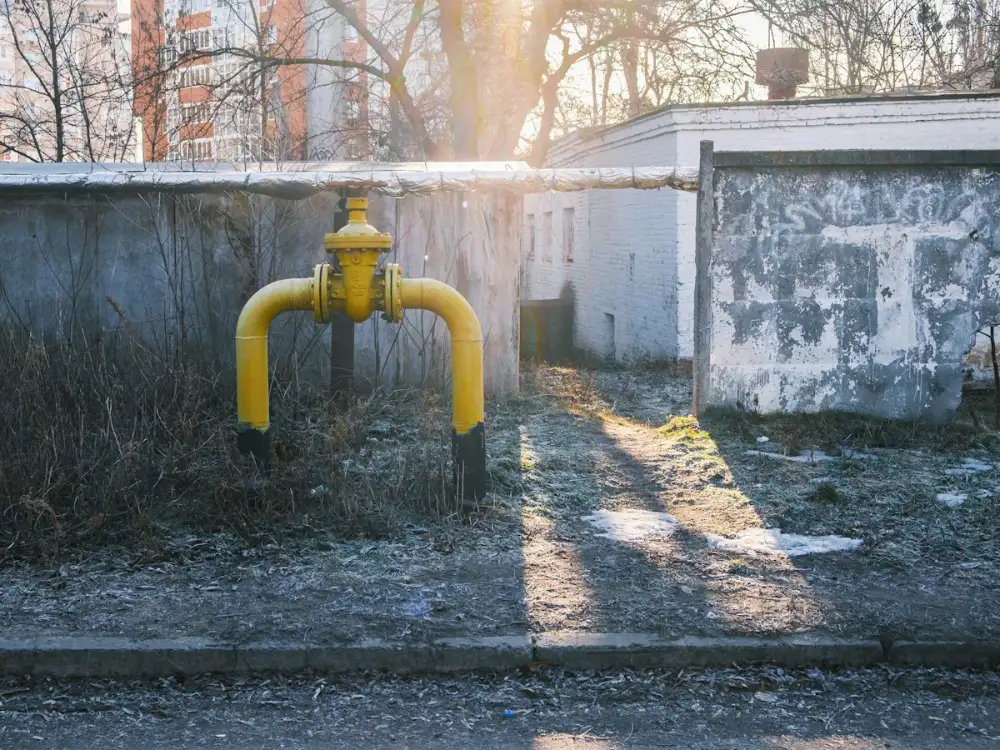 Yellow gas line and shut-off valve against an exterior wall