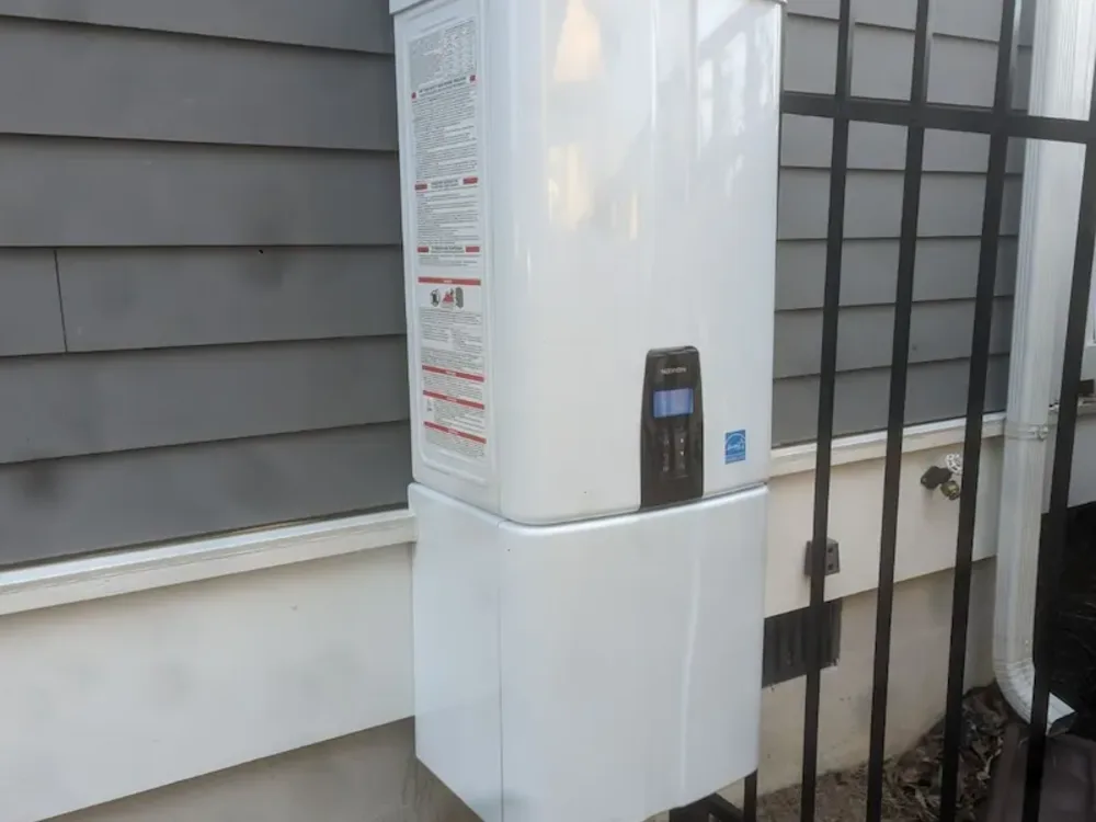 Tankless water heater installed on the outside wall of a home